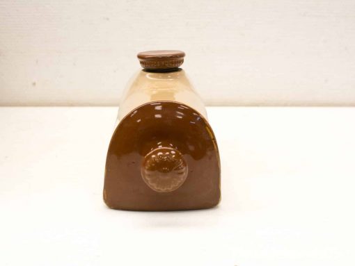 Charming vintage ceramic storage jar with lid, featuring a rustic two-tone design.