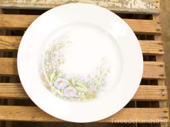 Elegant white porcelain plate with delicate floral design, perfect for table settings and décor.