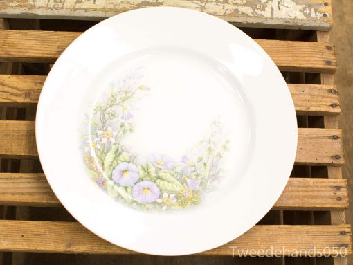 Elegant white porcelain plate with delicate floral design, perfect for table settings and décor.