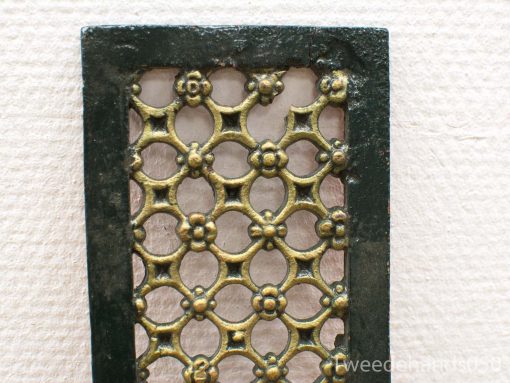 Vintage decorative panel with ornate lattice design, featuring green frame and golden accents.