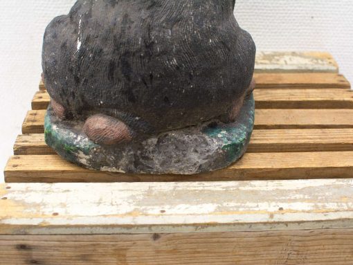 Sculpture of a brown bear on a rustic wooden platform, showcasing texture and artistry.
