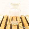 Elegant glass jar on rustic wooden surface for stylish storage and decor.