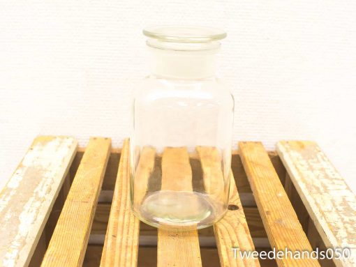 Elegant glass jar on rustic wooden surface for stylish storage and decor.