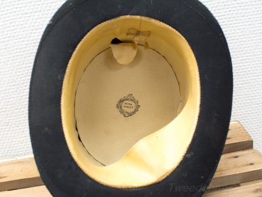 Elegant vintage top hat with beige lining, ribbon bow, and superior craftsmanship label.