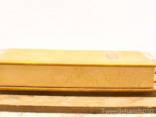 Charming vintage yellow book on weathered wood, perfect for collectors and literary enthusiasts.
