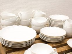 Elegant white dinnerware arranged on a rustic wooden surface, perfect for special occasions.