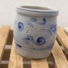 Elegant light blue ceramic pot with ZOUT and rustic wood base for stylish decor.