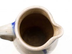 Vintage ceramic jug with blue decoration, showcasing rustic charm and artisanal craftsmanship.