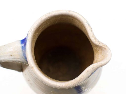 Vintage ceramic jug with blue decoration, showcasing rustic charm and artisanal craftsmanship.