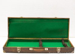 Vintage wooden case with plush green lining for secure storage of delicate items and instruments.