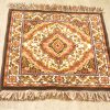 Vintage diamond pattern rug with floral designs in warm tones, perfect for home decor.