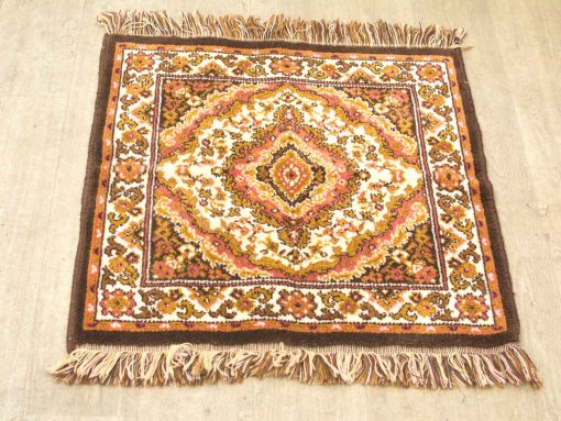 Vintage diamond pattern rug with floral designs in warm tones, perfect for home decor.