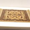 Elegant vintage beige rug with floral pattern and fringed edges, perfect for any decor.