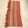 Handwoven vintage rug in red and brown, featuring intricate patterns and warm tones.