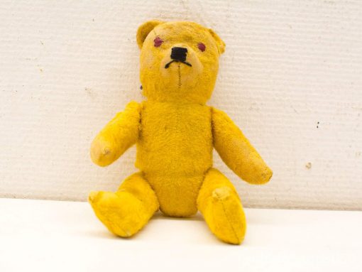 Charming vintage yellow teddy bear exuding warmth and nostalgia; perfect for collectors and decor.