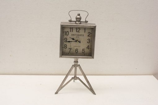 Antique 1870 metal clock with cream face and tripod stand, perfect vintage decor piece.