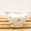 Elegant porcelain cream jug with rose design and gold trim, perfect for tea parties.