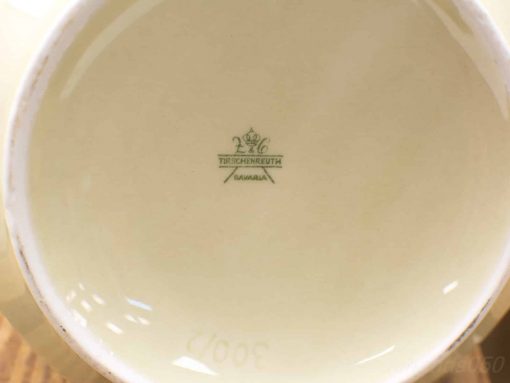 Vintage Tirschenreuth porcelain cup with crown emblem, creamy yellow color, and fine craftsmanship.