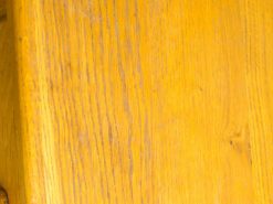 Rustic yellow wooden table with character, grain details, and a warm, inviting charm.