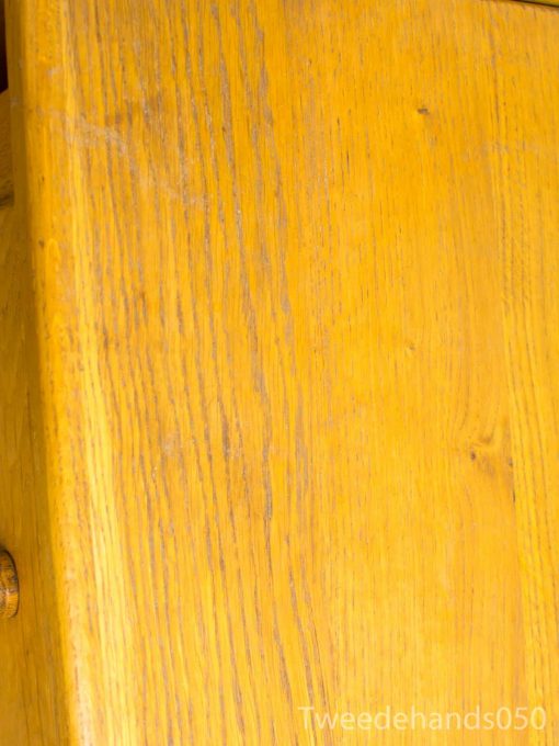 Rustic yellow wooden table with character, grain details, and a warm, inviting charm.