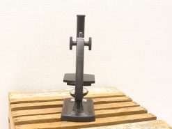Vintage black microscope on wooden surface, showcasing exquisite craftsmanship and timeless design.