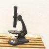 Sleek black microscope on a wooden table, perfect for detailed observations and research.