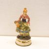Charming vintage ceramic figurine of a woman with a basket in traditional attire.
