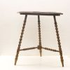 Vintage wooden table with turned legs, warm tone, and charming rustic details.