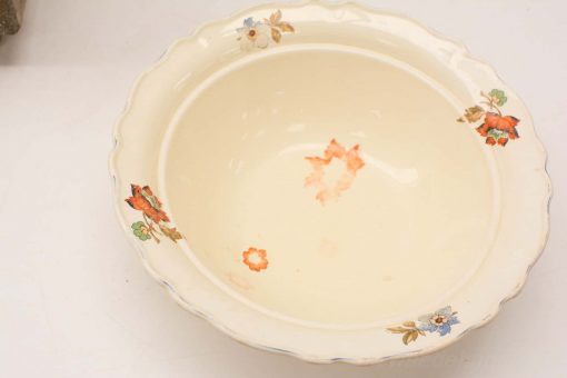 Vintage ceramic bowl with scalloped edges and vibrant floral motifs, perfect for decoration and use.