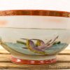 Elegant vintage ceramic bowl with hand-painted cranes and luxurious red and gold accents.