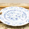Elegant blue and white porcelain plate featuring a floral design and ornate handles.