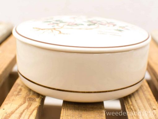 Elegant cream ceramic container with hand-painted floral design for decoration or storage.
