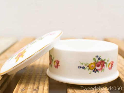 Elegant porcelain container with floral motifs, perfect for storing jewelry and small treasures.