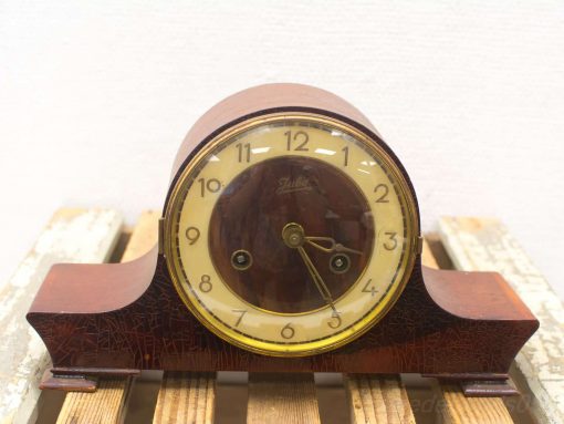 Vintage mahogany clock with elegant design, golden accents, and traditional numerals for timeless charm.