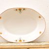 Elegant vintage oval serving platter with delicate orange and blue floral motifs.