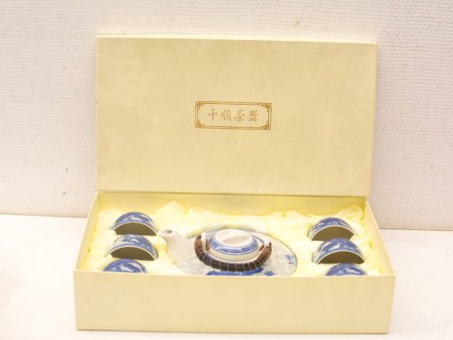 Elegant blue and white tea set in a luxurious yellow box, perfect gift for tea lovers.