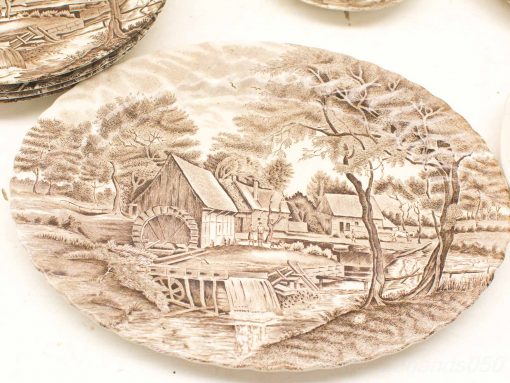 Vintage brown transferware plate featuring a charming pastoral scene with a watermill and cottages.