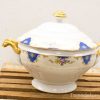 Elegant porcelain tureen with blue and gold accents, perfect for formal dining.