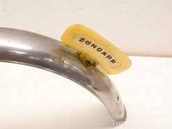 Vintage Zündapp chrome motorcycle fender with distinctive yellow label, showcasing classic craftsmanship.