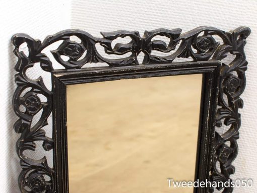 Elegant black-framed mirror with vintage floral design adds charm to any space.