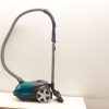 Stylish black and turquoise compact vacuum with telescoping wand for versatile cleaning.