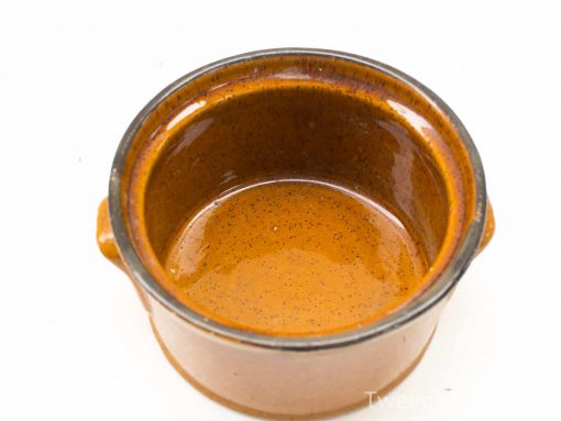 Stylish terracotta cooking pot with handles, perfect for serving stews and casseroles.