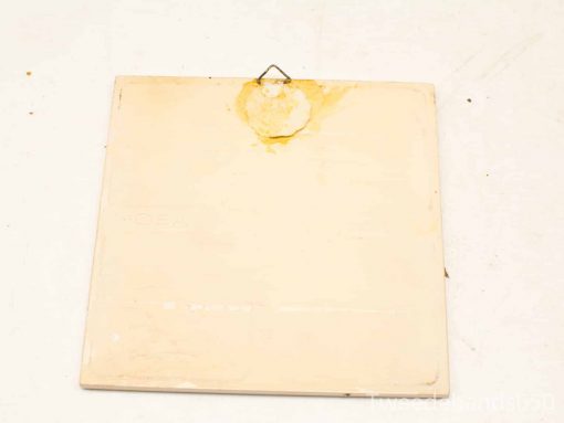 Weathered cardboard with hook, ideal for vintage wall decor and storytelling charm.