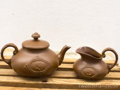 Elegant vintage brown teapot and creamer set with intricate relief designs, perfect for tea lovers.