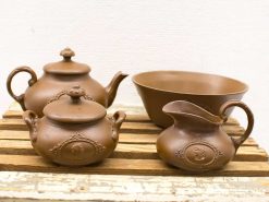 Charming vintage brown ceramic teapots, creamer, and bowl for a cozy kitchen atmosphere.