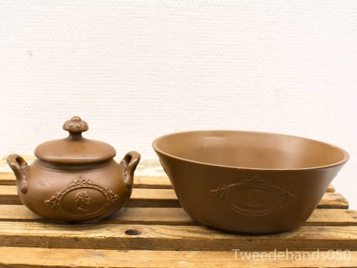 Handcrafted pottery set: lidded pot and bowl on wooden surface, showcasing traditional artisan design.