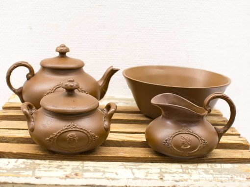 Charming vintage brown ceramic teapots, creamer, and bowl for a cozy kitchen atmosphere.