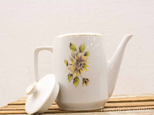 Elegant porcelain teapot with vibrant yellow floral design, perfect for tea service and decor.
