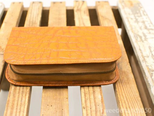 Vibrant orange bag with reptilian texture, stylish design, functional zippered compartment.