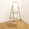 Aluminum step ladder with paint splatters, showcasing vintage style and practical design for home projects.